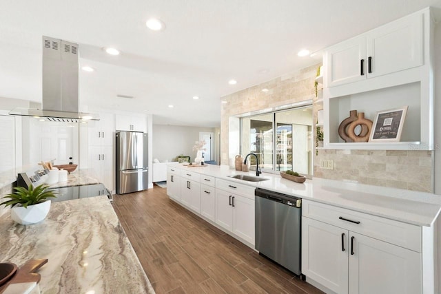 kitchen with appliances with stainless steel finishes, hardwood / wood-style floors, island range hood, sink, and white cabinets