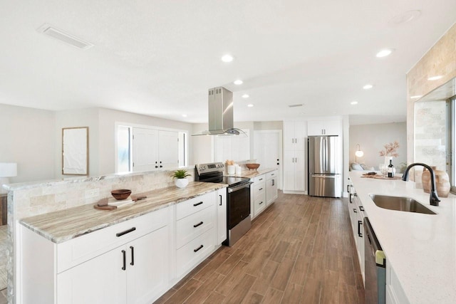 kitchen with white cabinetry, light stone countertops, island exhaust hood, and appliances with stainless steel finishes