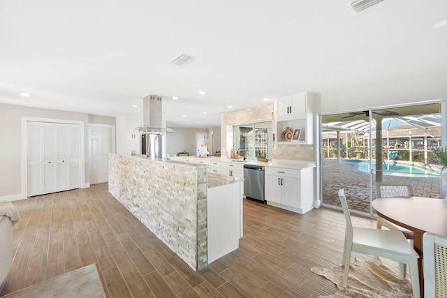 kitchen with white cabinetry, dishwasher, sink, and kitchen peninsula