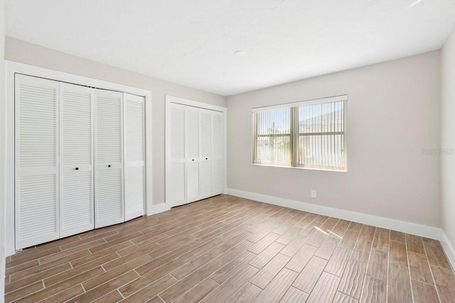 unfurnished bedroom featuring multiple closets