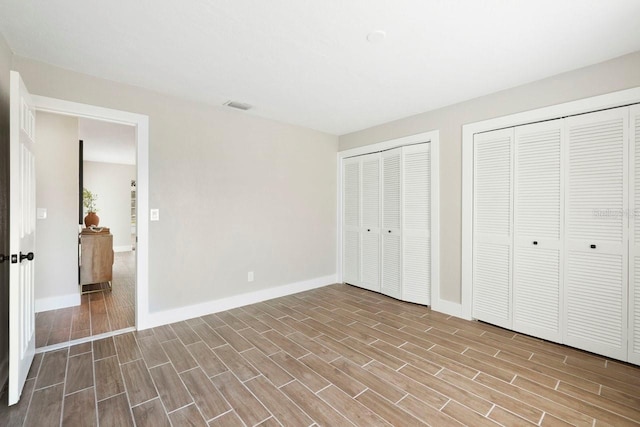 unfurnished bedroom with two closets