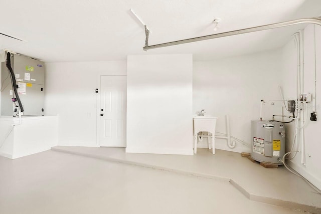 garage with water heater, sink, and heating unit