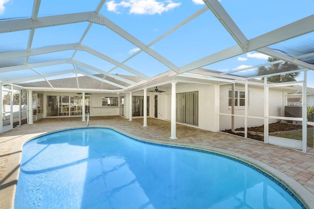 view of swimming pool featuring a patio area, ceiling fan, and glass enclosure