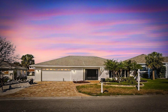 ranch-style home with a garage and a lawn