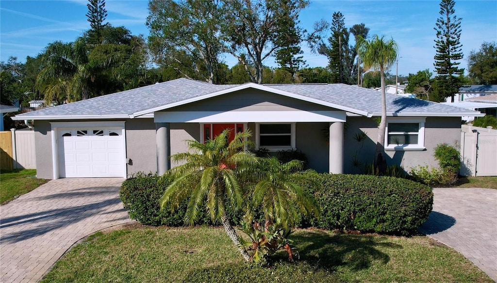 ranch-style house featuring a garage and a front yard