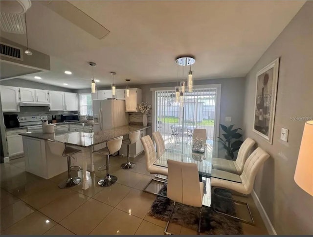 tiled dining space with an inviting chandelier