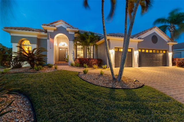 mediterranean / spanish-style home featuring a garage and a front lawn