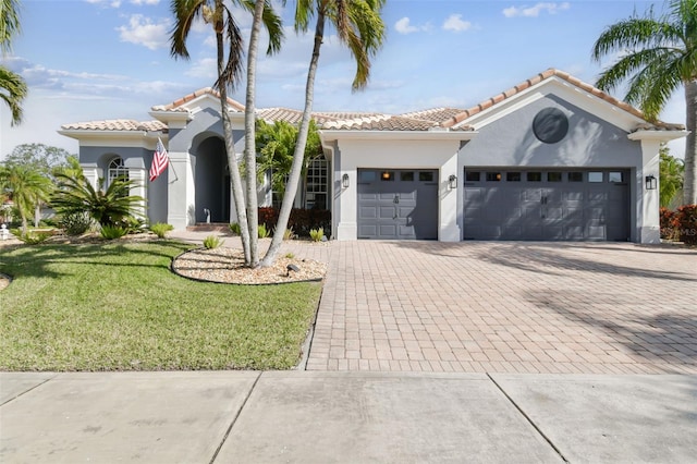 mediterranean / spanish house featuring a garage and a front yard