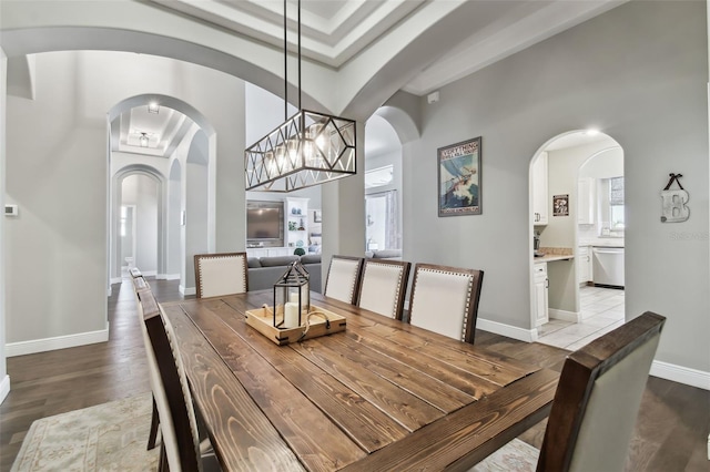 dining area featuring light hardwood / wood-style floors and a high ceiling