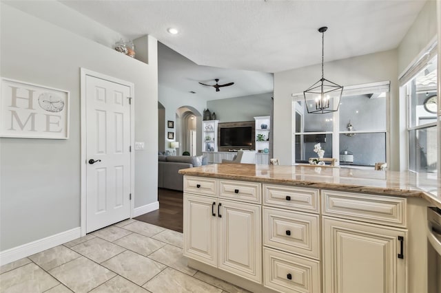 kitchen with pendant lighting, light stone counters, cream cabinets, light tile patterned flooring, and a chandelier