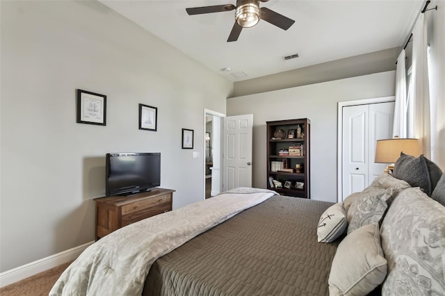 carpeted bedroom with ceiling fan and a closet