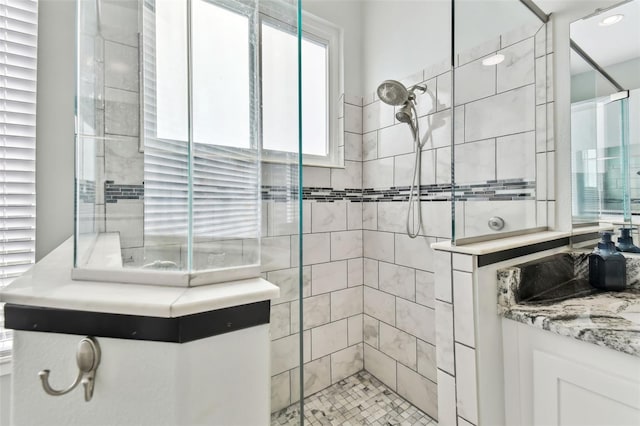 bathroom featuring vanity and tiled shower