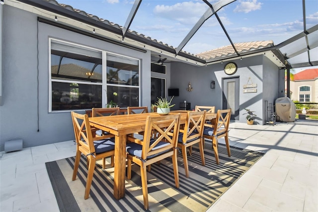 view of patio with area for grilling and glass enclosure