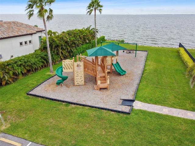 view of playground featuring a lawn and a water view