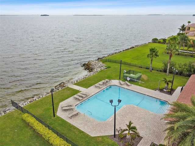 view of swimming pool featuring a patio area, a lawn, and a water view