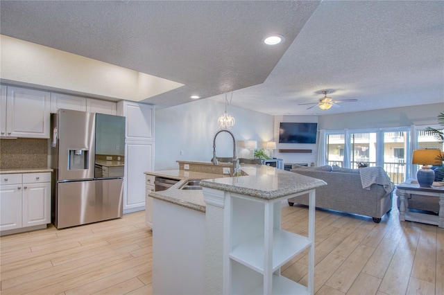 kitchen featuring decorative light fixtures, white cabinetry, sink, light hardwood / wood-style floors, and stainless steel appliances