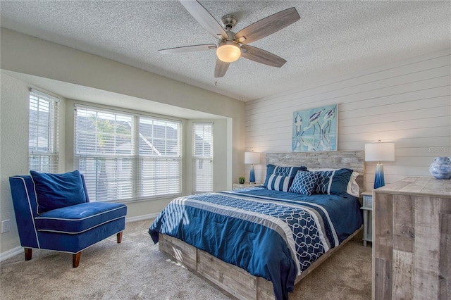 carpeted bedroom featuring ceiling fan and a textured ceiling