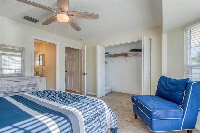 carpeted bedroom featuring multiple windows, a textured ceiling, ceiling fan, and a closet