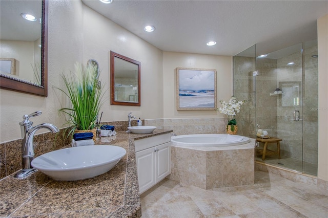 bathroom with vanity, separate shower and tub, and a textured ceiling