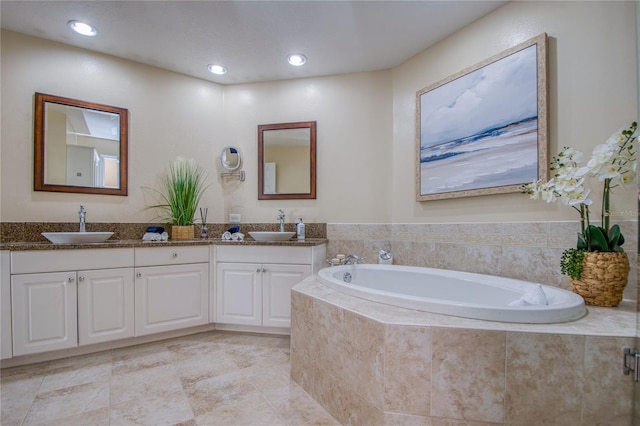 bathroom featuring vanity and tiled tub