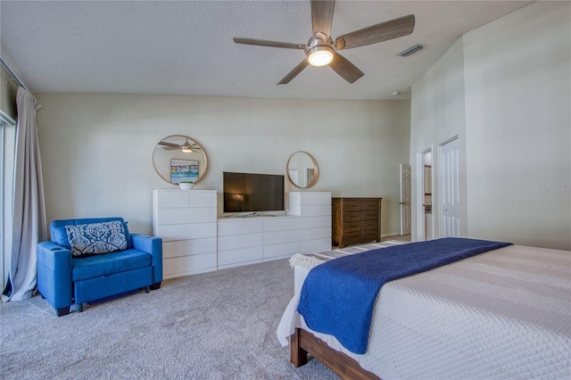 carpeted bedroom featuring ceiling fan and a textured ceiling