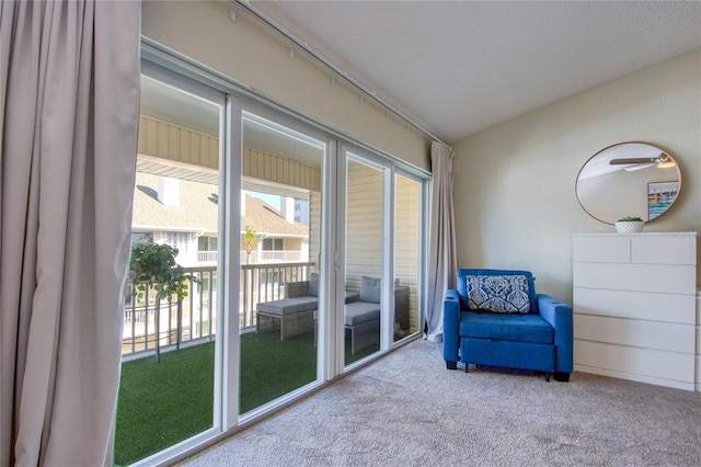 sitting room featuring lofted ceiling and carpet flooring