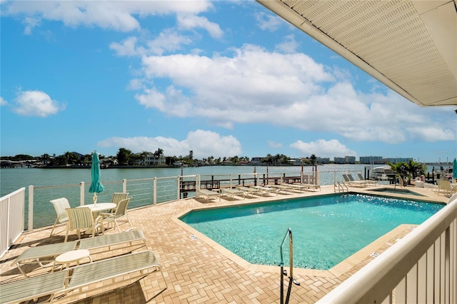 view of swimming pool with a water view and a patio area