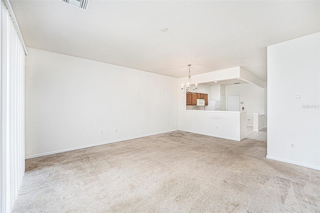 unfurnished living room featuring light carpet and an inviting chandelier