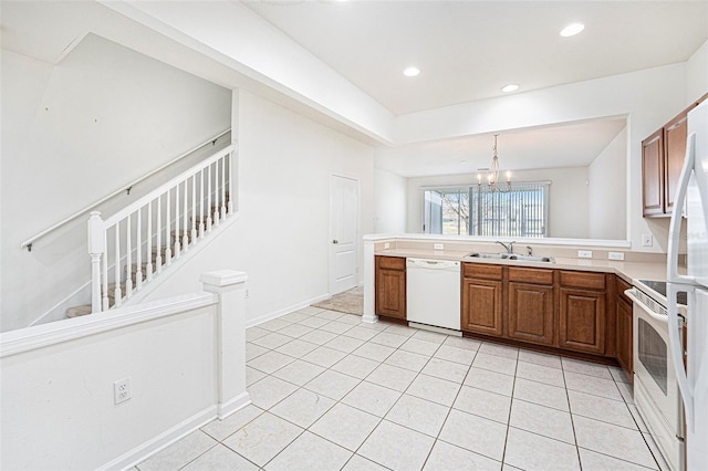 kitchen featuring sink, a chandelier, light tile patterned floors, pendant lighting, and white appliances