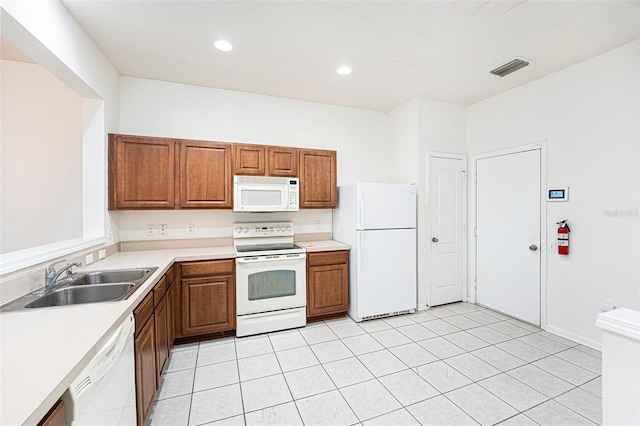 kitchen featuring sink, light tile patterned floors, and white appliances