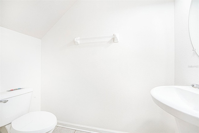 bathroom featuring sink, vaulted ceiling, and toilet