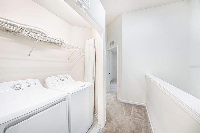 clothes washing area featuring washing machine and dryer and light carpet