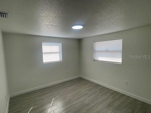 empty room featuring hardwood / wood-style flooring and a textured ceiling