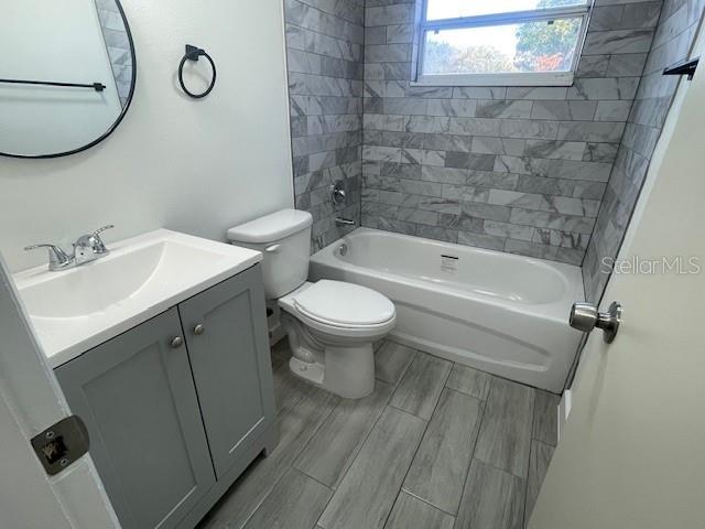 full bathroom with vanity, toilet, and tiled shower / bath