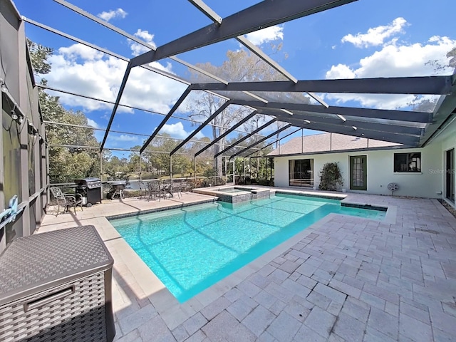 view of pool featuring a patio, glass enclosure, and an in ground hot tub