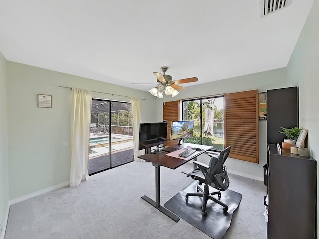 carpeted home office featuring ceiling fan