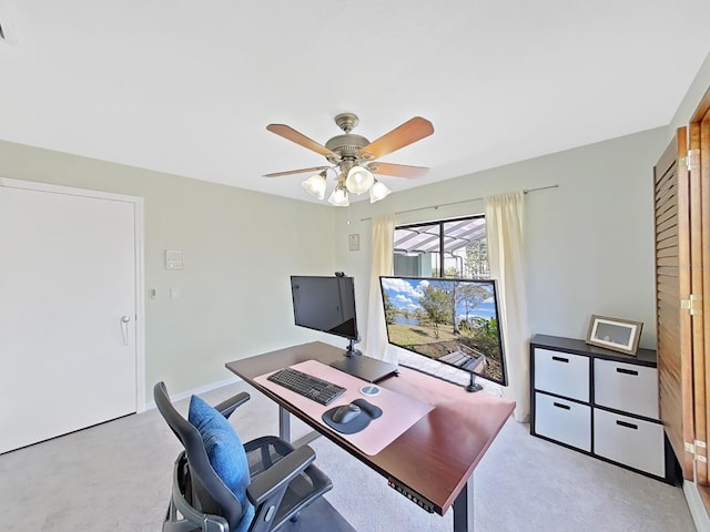 carpeted office space featuring ceiling fan