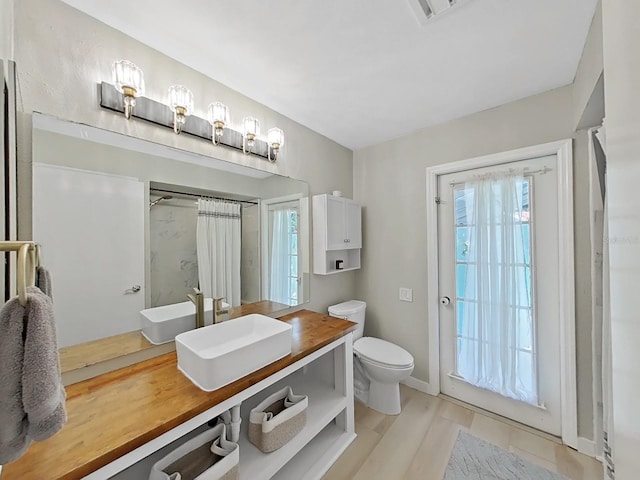 bathroom featuring vanity, plenty of natural light, and toilet