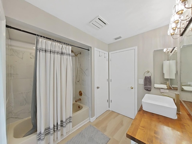 bathroom with vanity, a notable chandelier, hardwood / wood-style flooring, and shower / bath combination with curtain