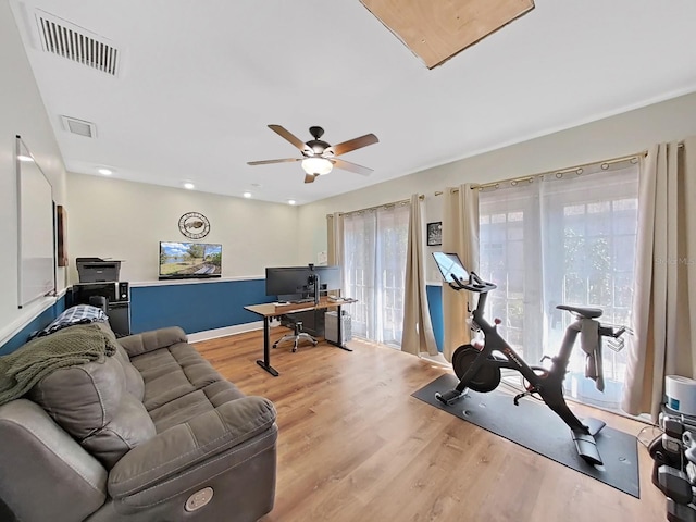 workout area featuring ceiling fan and light wood-type flooring