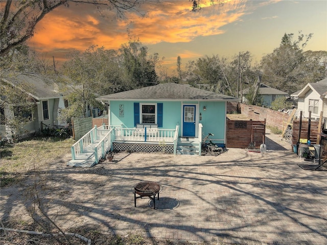 view of front of home featuring a porch and a fire pit