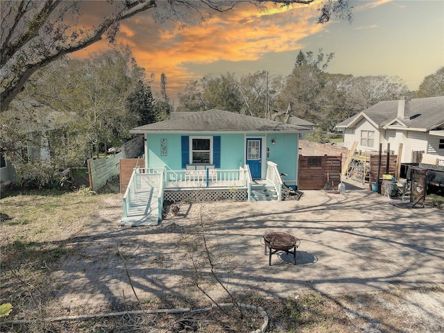 view of front facade featuring covered porch and a fire pit