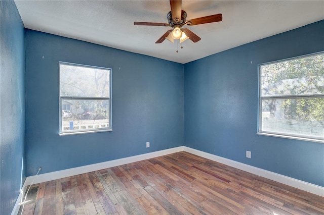 empty room with hardwood / wood-style flooring, a wealth of natural light, and ceiling fan