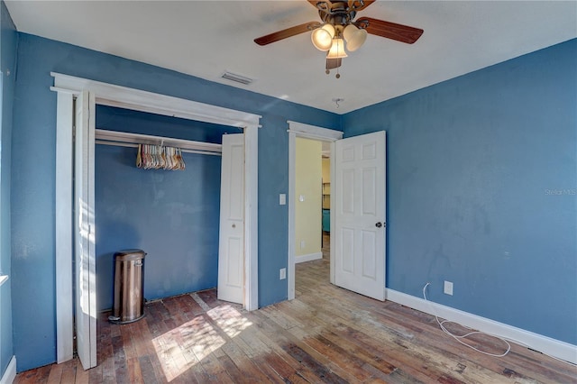 unfurnished bedroom featuring hardwood / wood-style flooring, ceiling fan, and a closet