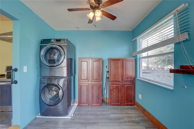 washroom featuring ceiling fan, stacked washer and clothes dryer, and light hardwood / wood-style floors