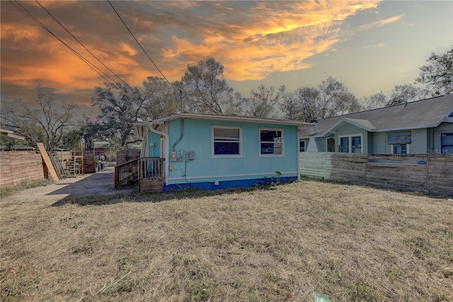 back house at dusk with a yard