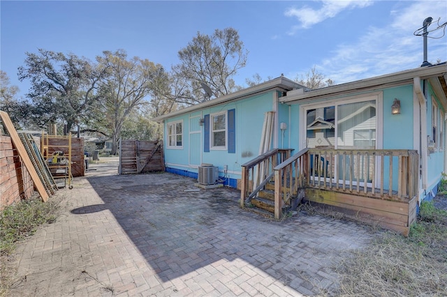 view of front of property with central AC and a patio