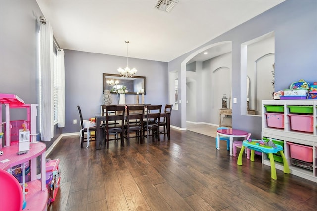 dining room with an inviting chandelier and dark hardwood / wood-style floors