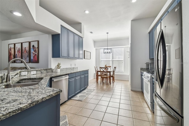 kitchen featuring sink, refrigerator with ice dispenser, hanging light fixtures, white range with gas cooktop, and stainless steel dishwasher