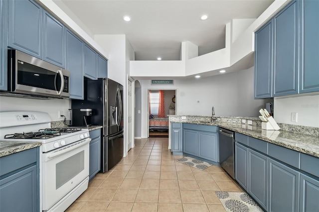 kitchen with blue cabinets, light tile patterned floors, sink, and appliances with stainless steel finishes